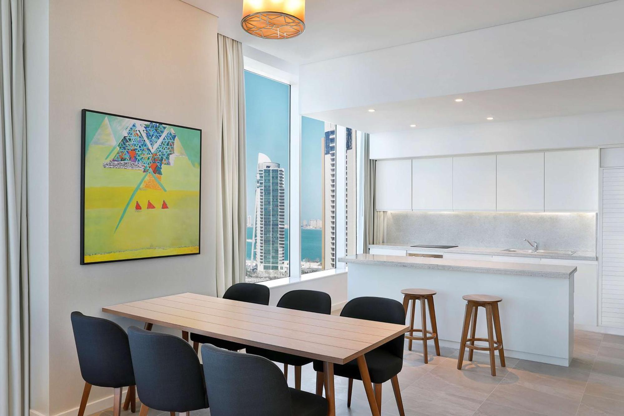 Aleph Doha Residences, Curio Collection By Hilton Luaran gambar The kitchen and dining area of a typical apartment